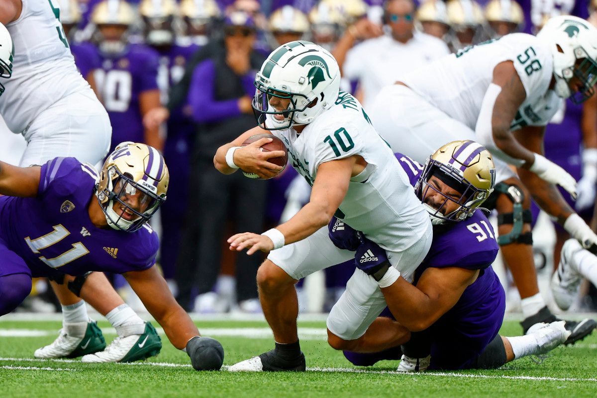 Washington Huskies defensive lineman Tuli Letuligasenoa (91) tackles Michigan State Spartans quarterback Payton Thorne (10) for no gain during the second quarter at Alaska Airlines Field at Husky Stadium.