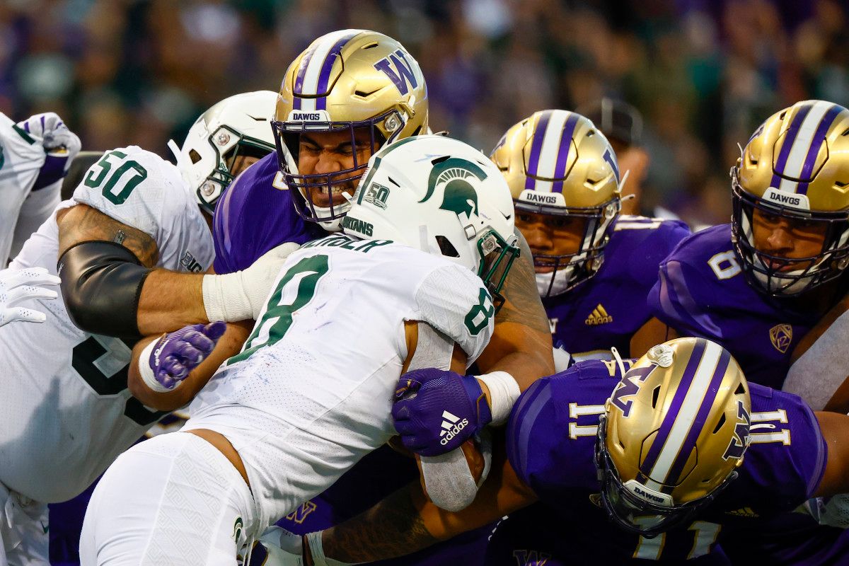 Washington Huskies defensive lineman Voi Tunuufi (90) tackles Michigan State Spartans running back Jalen Berger (8) during the third quarter at Alaska Airlines Field at Husky Stadium.