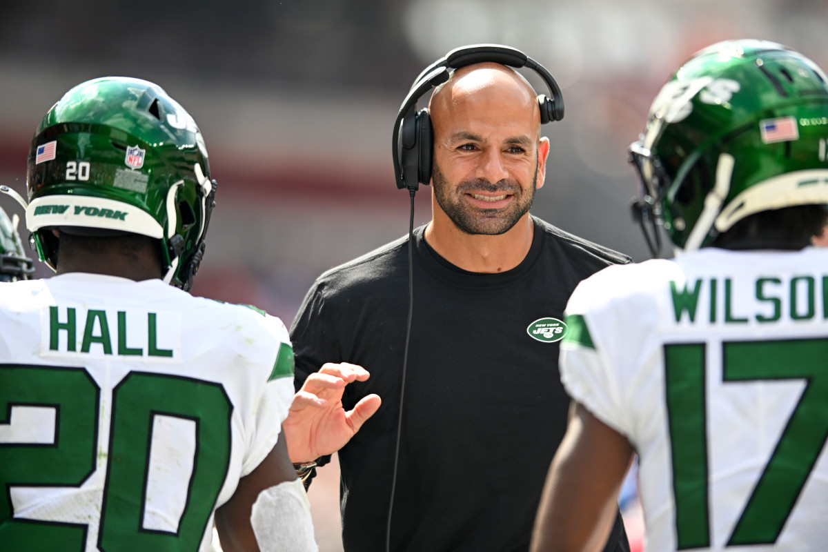 Jets coach Robert Saleh smiles as he greets players on the sideline during a victory over the Browns