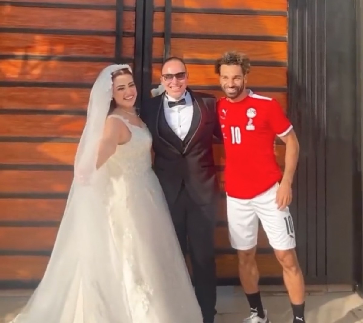 Mo Salah pictured (right) posing with a newly-married couple on their wedding day