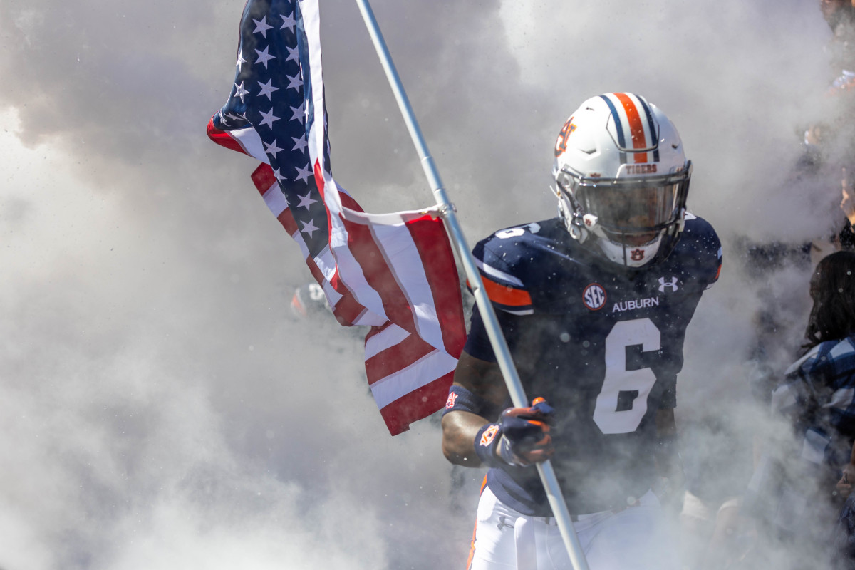 Keionte Scott carries the American flag out of the tunnel vs Missouri.