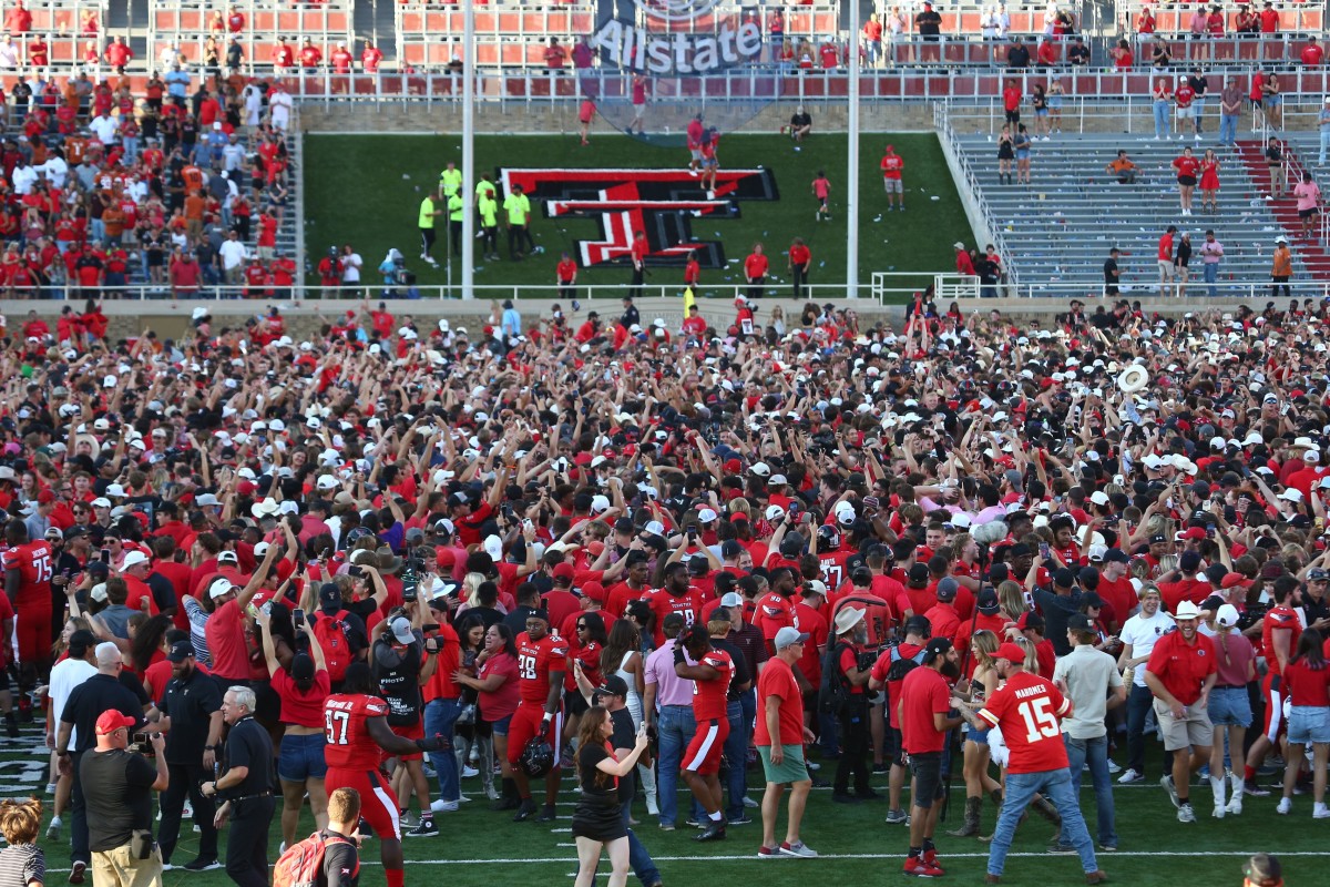 The Texas Tech Red Raiders student body celebrate on the field after defeating the Texas Longhorns in overtime at Jones AT&T Stadium and Cody Campbell Field.