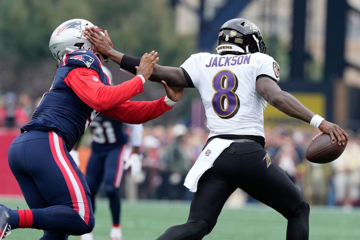 Ravens quarterback Lamar Jackson tries to get away from the Patriots' Matthew Judon during Sunday's game.