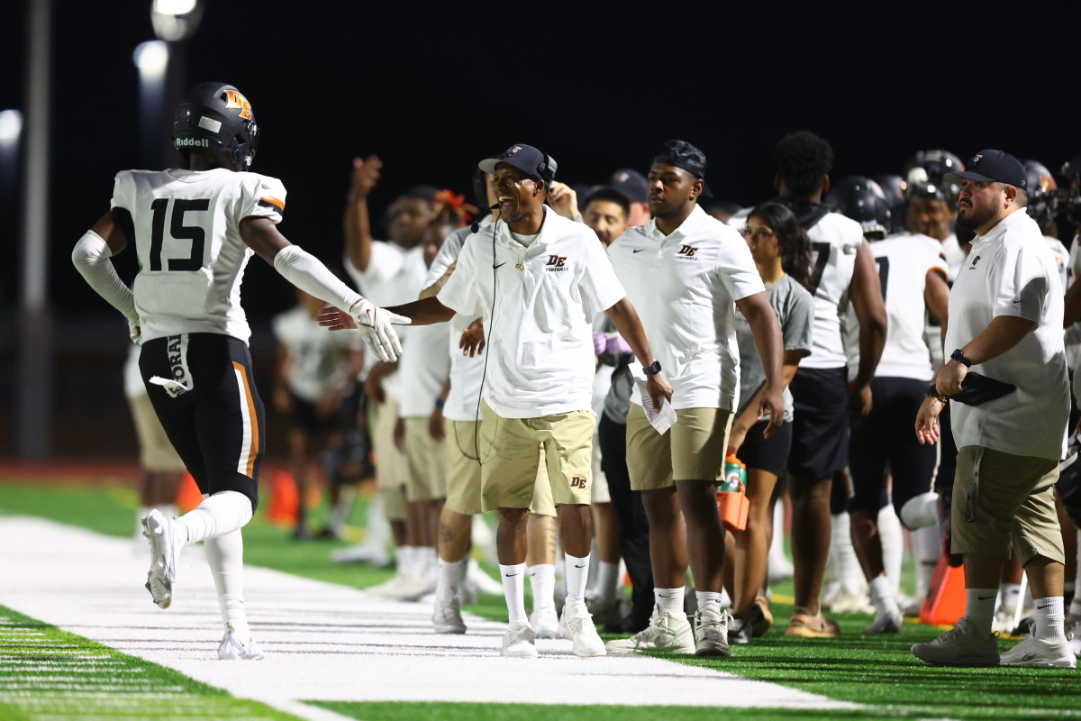 Mark Carter (center, high-fiving) and his brother, Marcus (not pictured), know that a Black coach has never won a state title in Arizona. Their response: “Challenge accepted.” 