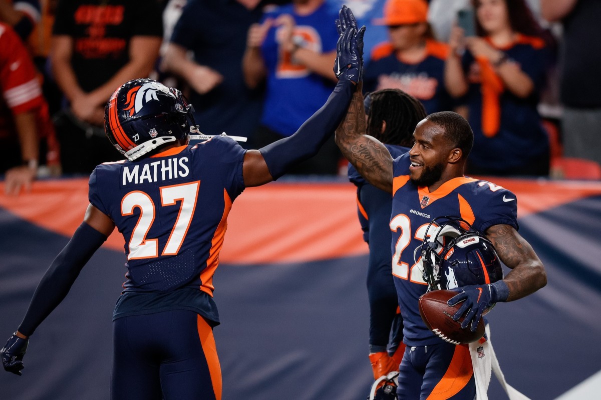 Denver Broncos safety Kareem Jackson (22) celebrates his fumble recovery with cornerback Damarri Mathis (27) in the fourth quarter against the San Francisco 49ers at Empower Field at Mile High.