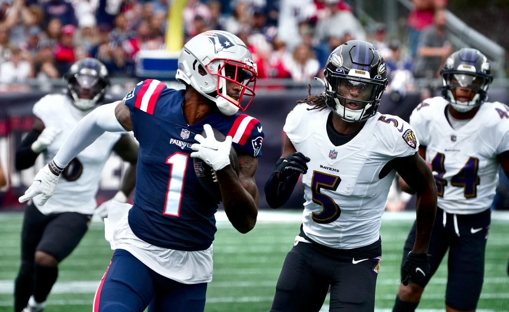 Patriots receiver DeVante Parker looks over his shoulder to Raven defenders in pursuit after a 40yd gain in the first quarter. Patriots home opener against the Baltimore Ravens on Sept 25, 2022.