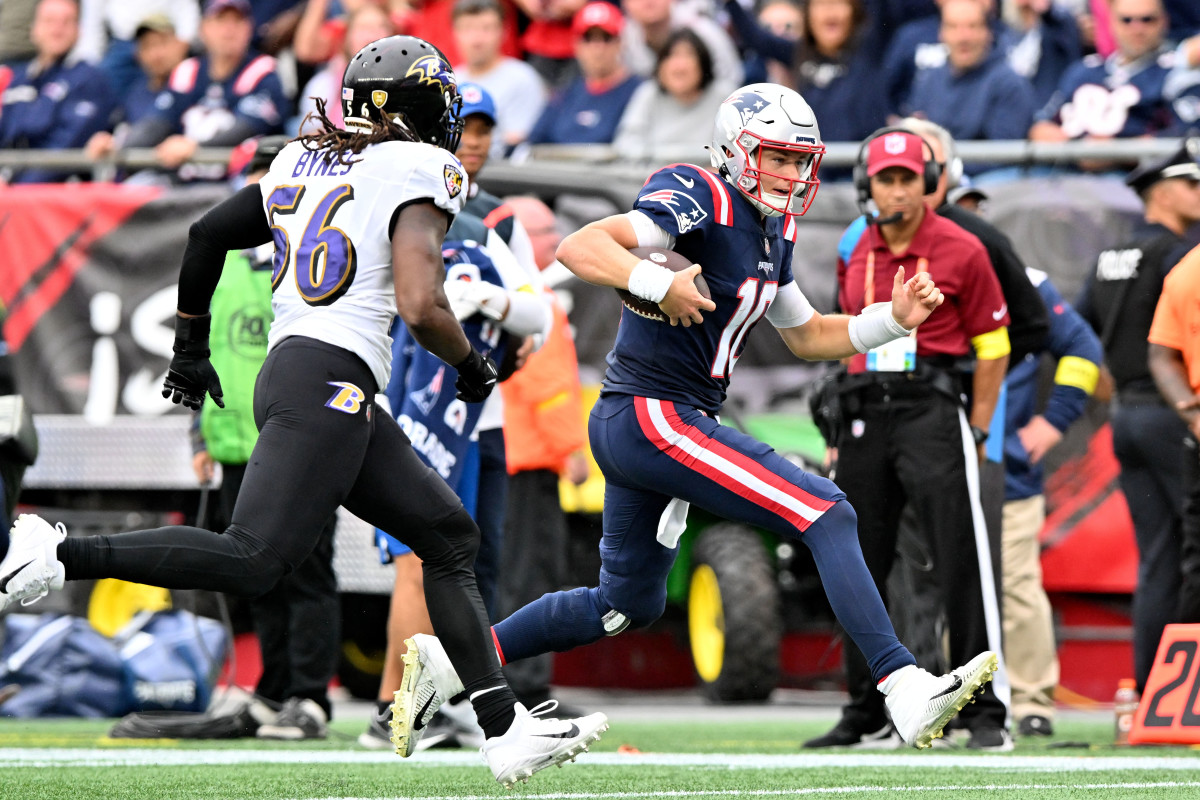 Sep 25, 2022; Foxborough, Massachusetts, USA; New England Patriots quarterback Mac Jones (10) runs with the ball in front of Baltimore Ravens linebacker Josh Bynes (56) during the second half at Gillette Stadium. Mandatory Credit: Brian Fluharty-USA TODAY Sports
