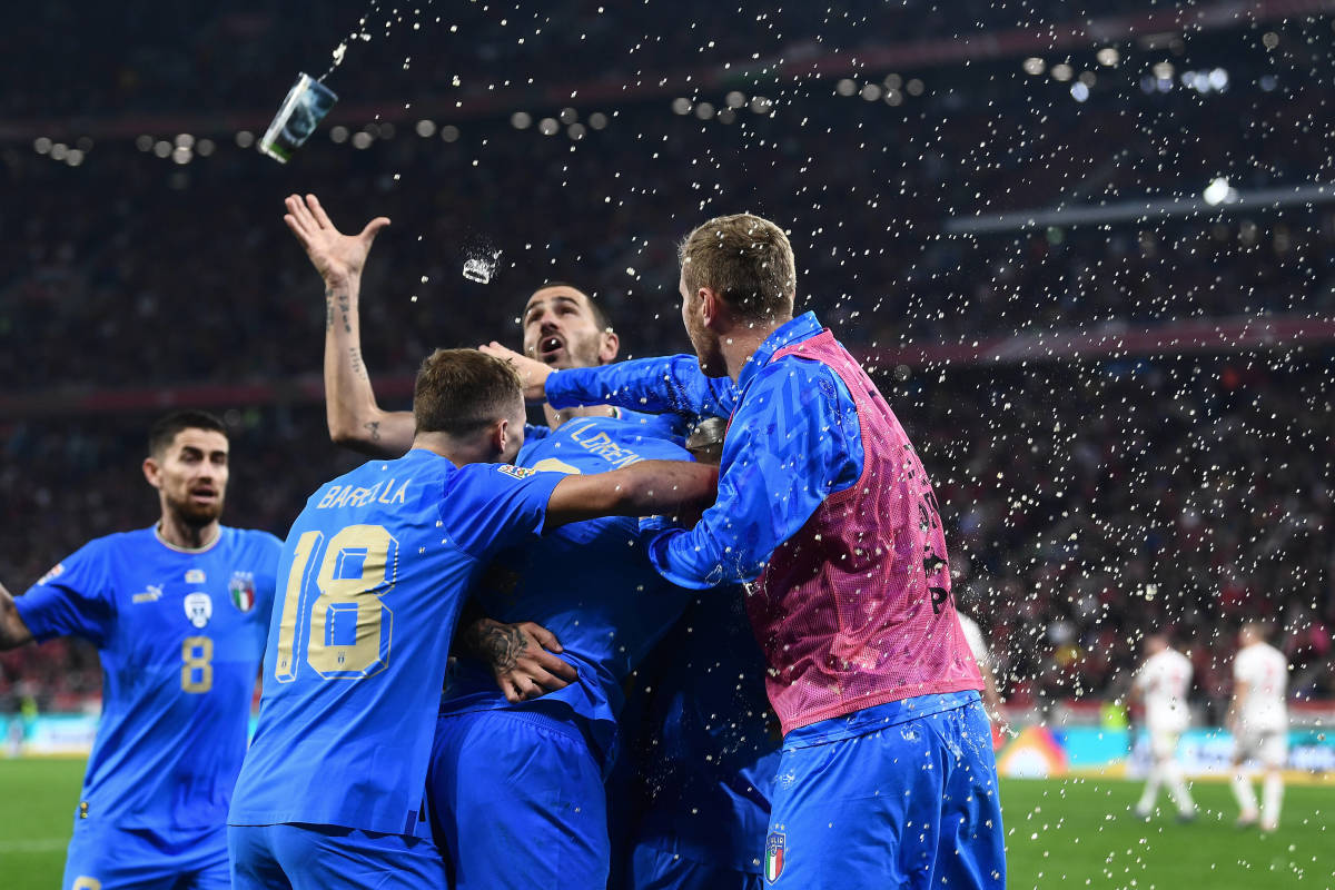 Italy's players pictured celebrating a goal during their 2-0 win over Hungary in Budapest in September 2022 as a drink thrown by a fan flies overhead