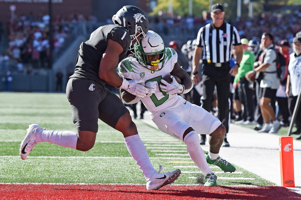 Oregon Ducks running back Mar'Keise Irving (0) crosses the goal line for a touchdown against Washington State Cougars linebacker Daiyan Henley (1) in the second half at Gesa Field at Martin Stadium. Ducks won 44-41.