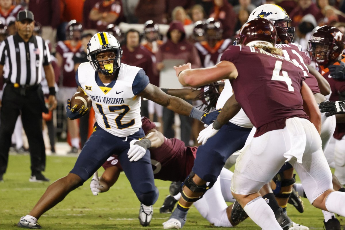 Sep 22, 2022; Blacksburg, Virginia, USA; Virginia Tech Hokies defensive lineman TyJuan Garbutt (45) grabs West Virginia Mountaineers tight end CJ Donaldson (12) as Hokies linebacker Dax Hollifield (4) and defensive lineman Jaylen Griffin (41) close in during the second half at Lane Stadium.