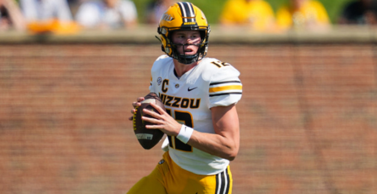 Missouri Tigers quarterback Brady Cook attempts a pass during a college football game in the SEC.