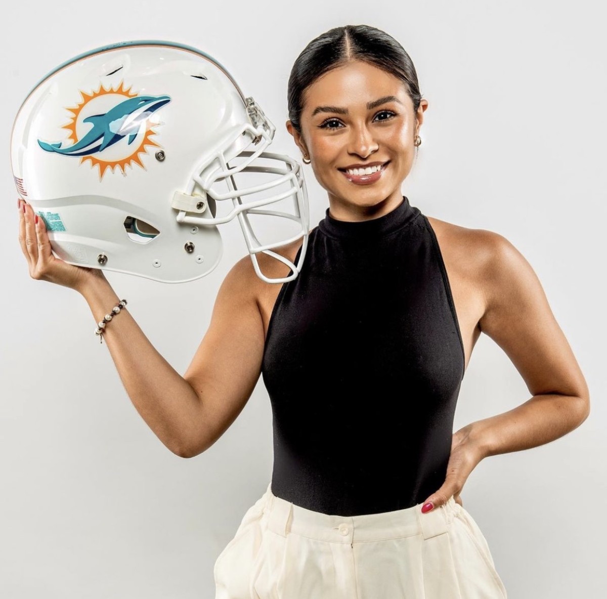 Paola Argueta holding a Miami Dolphins helmet