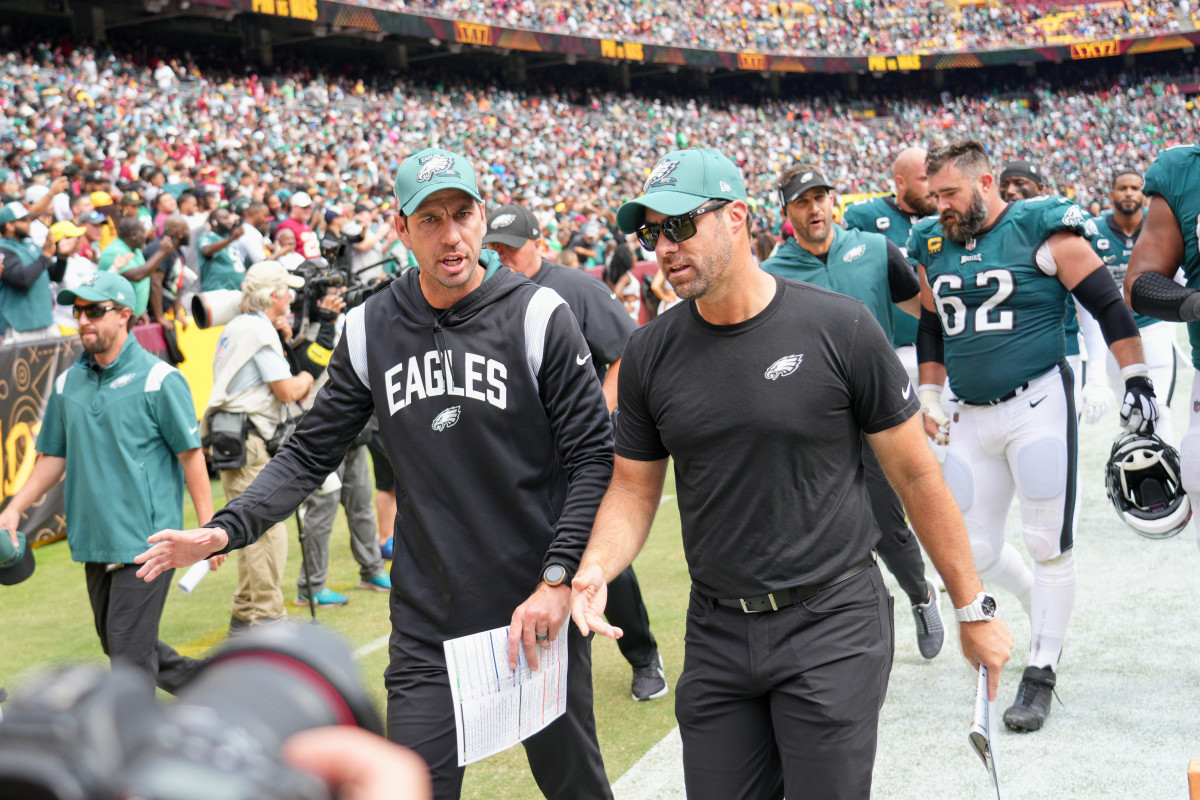 Shane Steichen and Jonathan Gannon walk off the field at halftime of an Eagles game