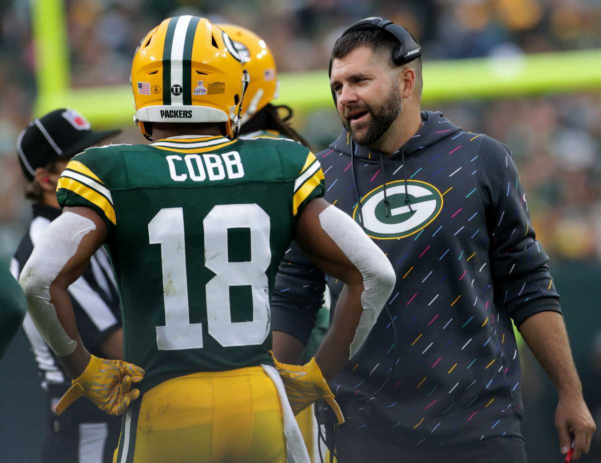 Jason Vrable talks to Randall Cobb on the sideline during a Packers game