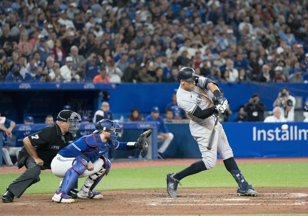 Sep 28, 2022; Toronto, Ontario, CAN; New York Yankees designated hitter Aaron Judge (99) hits his 61st home run scoring two runs against the Toronto Blue Jays during the seventh inning at Rogers Centre. (Nick Turchiaro-USA TODAY Sports)