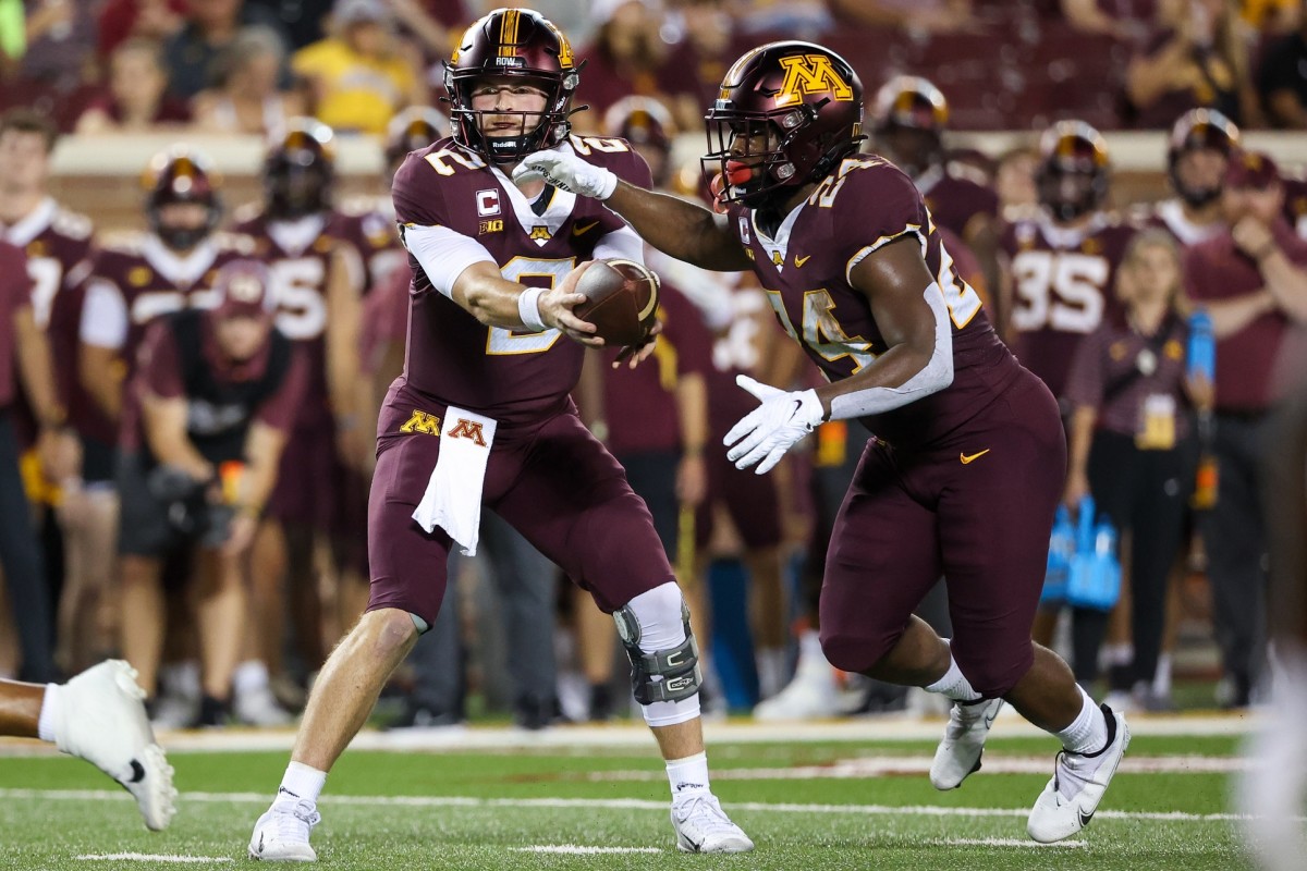 Sep 1, 2022; Minneapolis, Minnesota, USA; Minnesota Golden Gophers quarterback Tanner Morgan (2) hands the ball off to Minnesota Golden Gophers running back Mohamed Ibrahim (24) against the New Mexico State Aggies during the first quarter at Huntington Bank Stadium.
