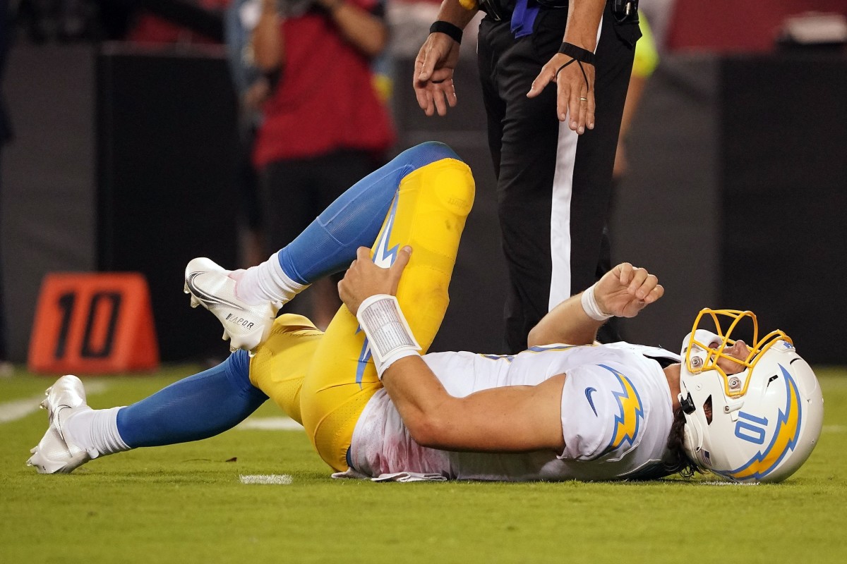 Los Angeles Chargers quarterback Justin Herbert (10) reacts after being hit by Kansas City Chiefs defensive end Mike Danna (51) during the second half at GEHA Field at Arrowhead Stadium.