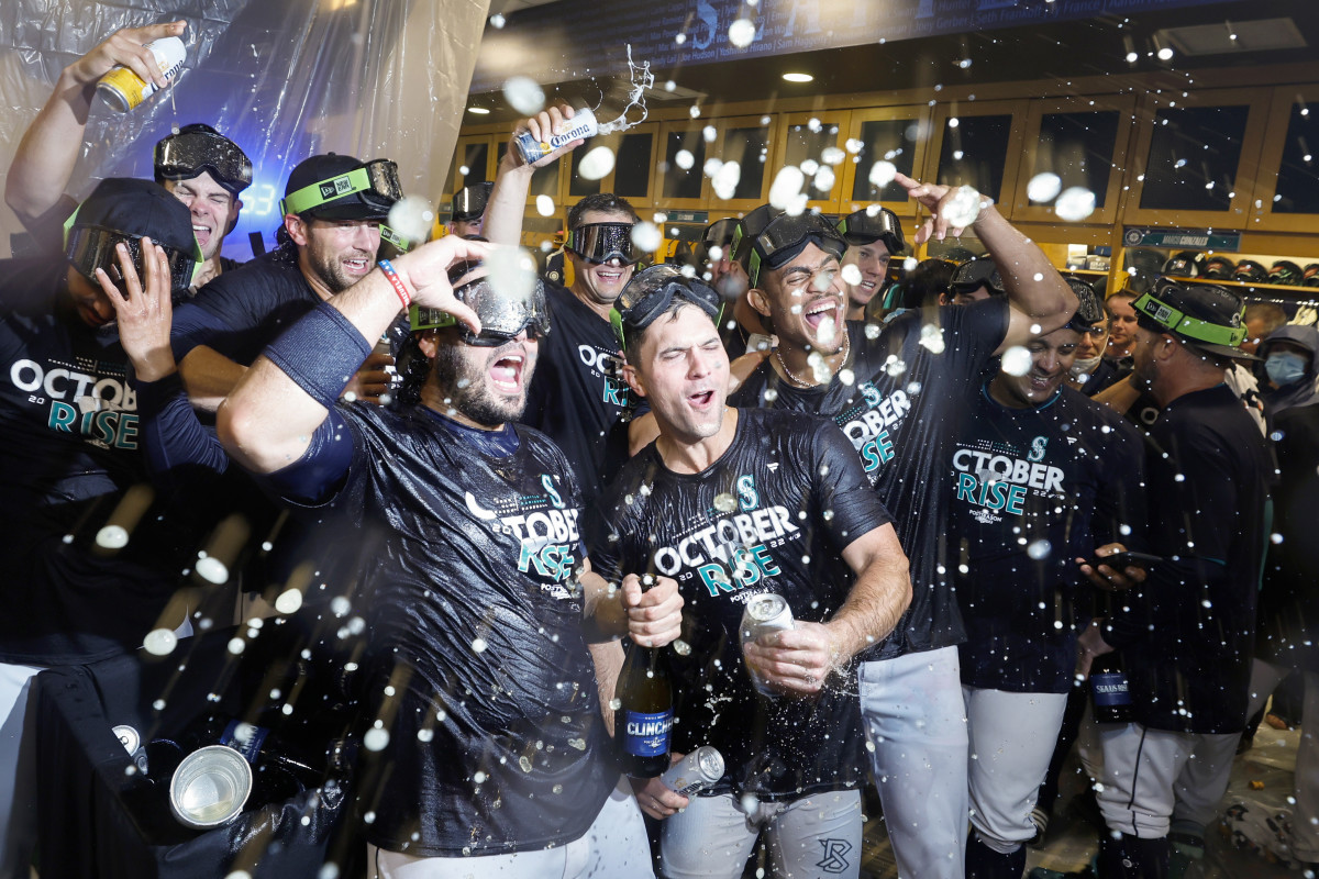 Sep 30, 2022; Seattle, Washington, USA; Seattle Mariners third baseman Eugenio Suarez (front row, left), second baseman Adam Frazier (front row, middle) and center fielder Julio Rodriguez (front row, right) celebrate in the clubhouse following a 2-1 victory against the Oakland Athletics to clinch a wild card playoff berth at T-Mobile Park.