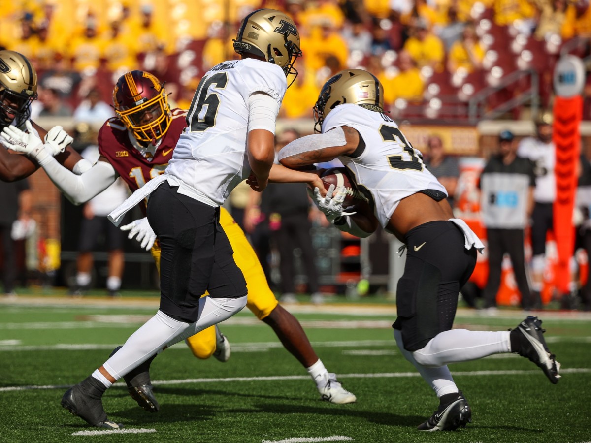 Oct 1, 2022; Minneapolis, Minnesota, USA; Purdue Boilermakers quarterback Aidan O'Connell (16) hands the ball off to running back Dylan Downing (38) during the first quarter at Huntington Bank Stadium.