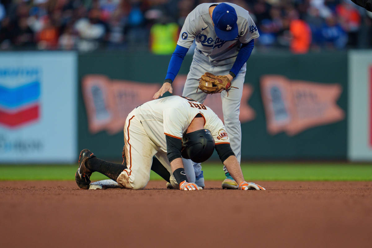 SF Giants first baseman Brandon Belt stays on the ground after an ugly slide into second base in front of Dodgers infielder Trea Turner. (2022)