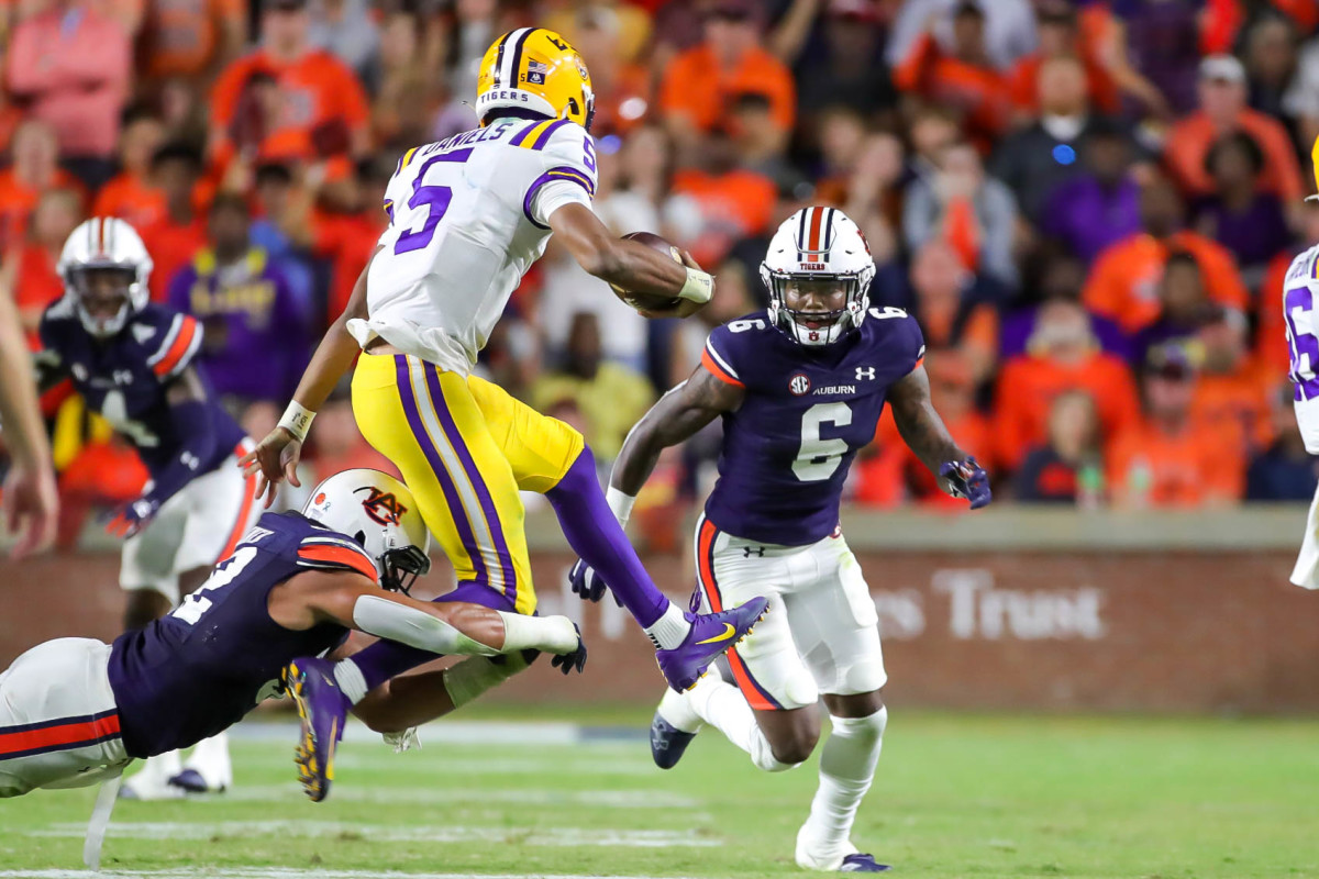 LSU Tigers quarterback Jayden Daniels (5) tries to jump clear of the Tiger defender during the game between the LSU Tigers and the Auburn Tigers at Jordan-Hare Stadium on Oct. 1, 2022.