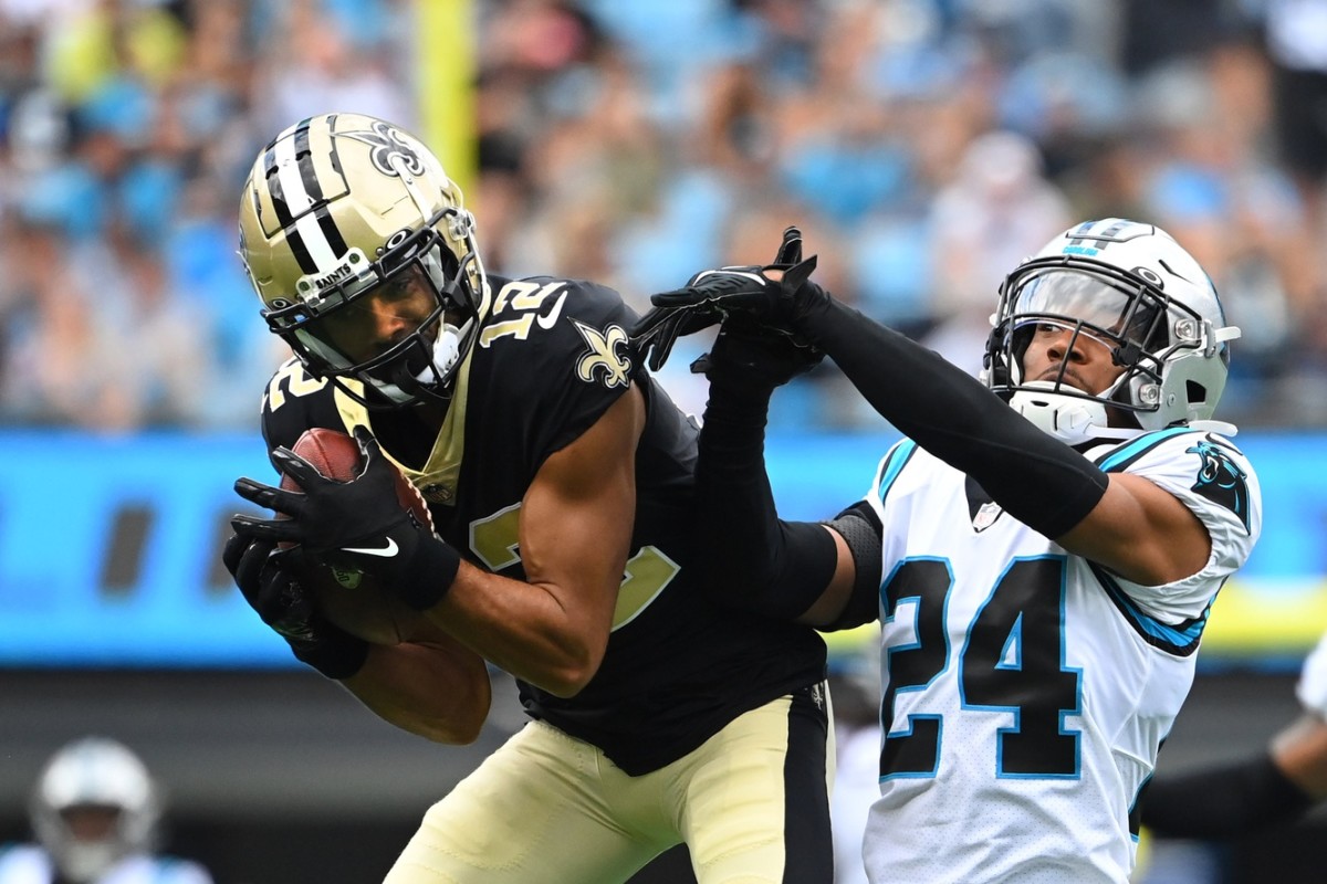 New Orleans Saints receiver Chris Olave (12) catches the ball as Carolina Panthers cornerback CJ Henderson (24) defends. Mandatory Credit: Bob Donnan-USA TODAY