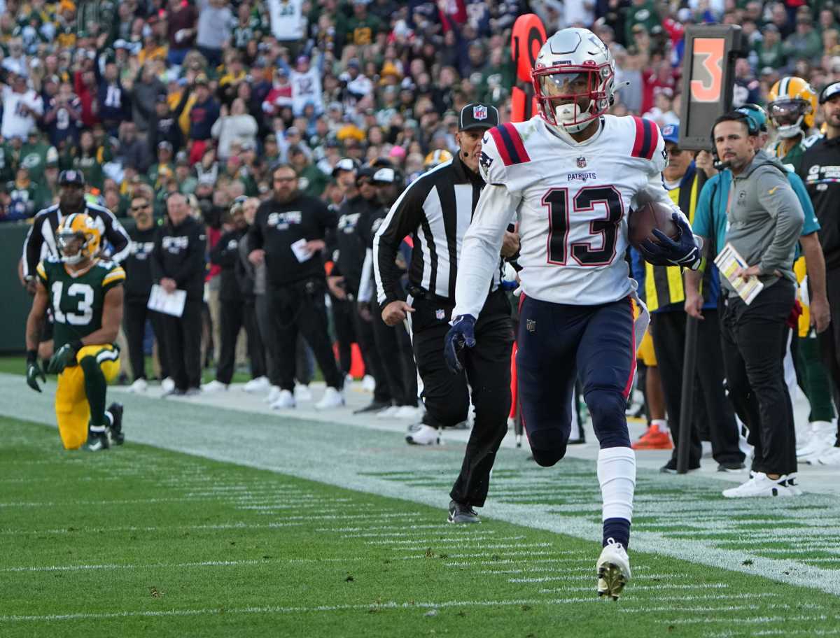 New England Patriots defensive back Jack Jones returns an interception thrown by Green Bay Packers quarterback Aaron Rodgers for a touchdown during the second quarter of their game Sunday, October 2, 2022 at Lambeau Field in Green Bay, Wis.