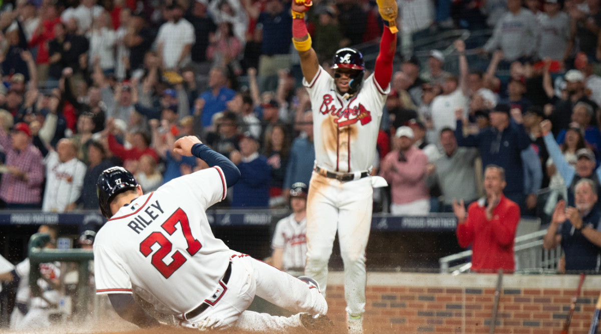 Atlanta Braves Ronald Acuna Jr. and Austin Riley score on a single hit by Travis d’Arnaud in the third inning of a baseball against the New York Mets, Sunday, Oct. 2, 2022, in Atlanta. (AP Photo/Hakim Wright Sr.)