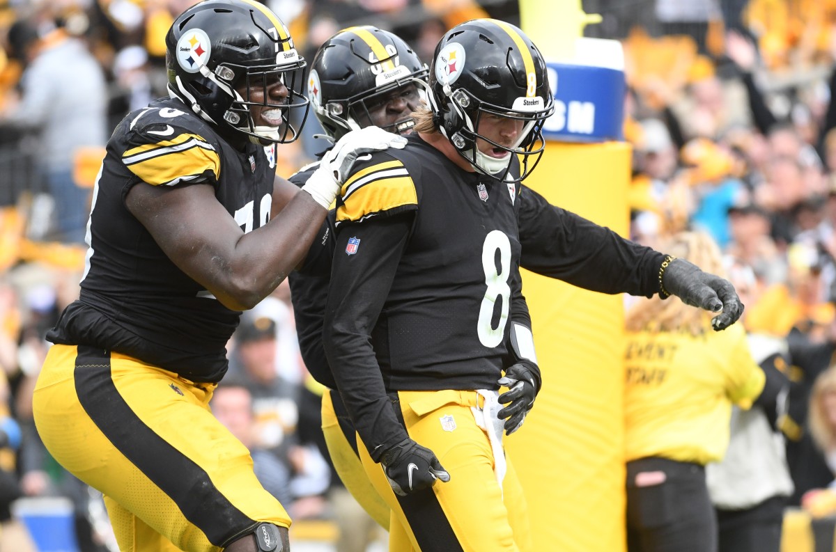 Steelers quarterback Kenny Pickett celebrates with his teammates after scoring a touchdown in his first professional game.