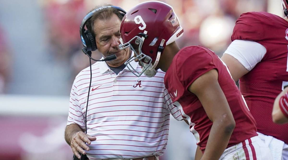 Alabama head coach Nick Saban and quarterback Bryce Young talk on the sidelines during a game.