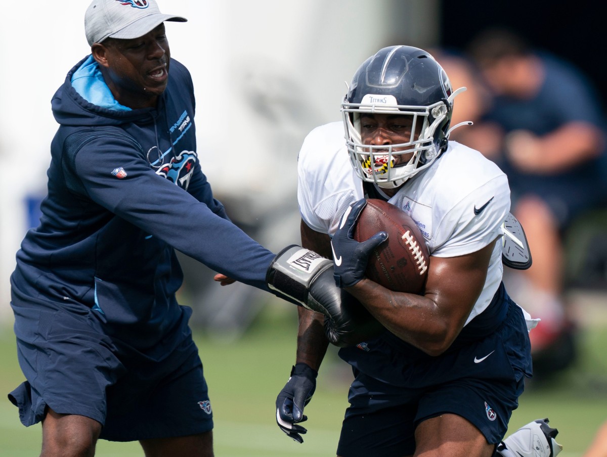 Tennessee Titans running back Julius Chestnut (36) holds on to the ball as running backs coach Tony Dews tries to punch it out during a training camp practice at Ascension Saint Thomas Sports Park Thursday, Aug. 4, 2022, in Nashville, Tenn.