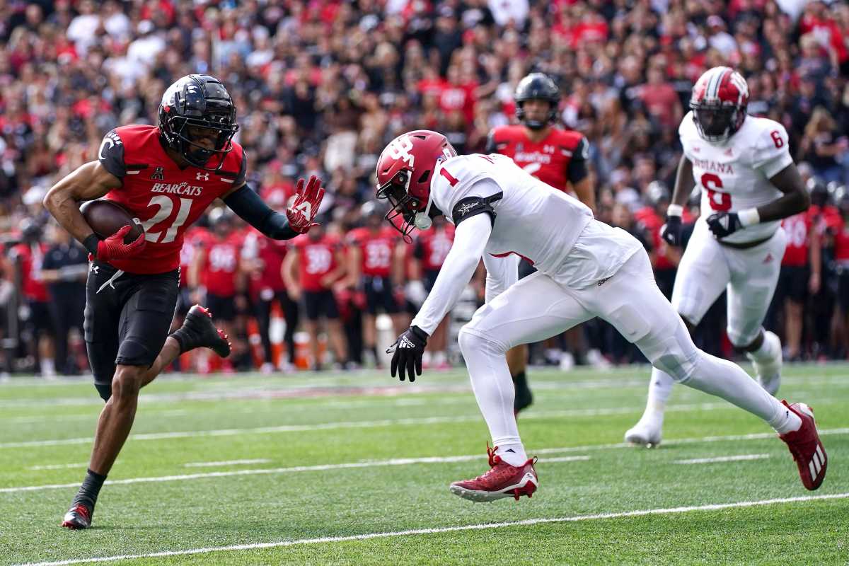 Cincinnati Bearcats wide receiver Tyler Scott (21) runs toward the end zone after a catch as Indiana Hoosiers defensive back Devon Matthews (1) defends in the first quarter of a college football game, Saturday, Sept. 24, 2022, at Nippert Stadium in Cincinnati. Ncaaf Indiana Hoosiers At Cincinnati Bearcats Sept 24 0224