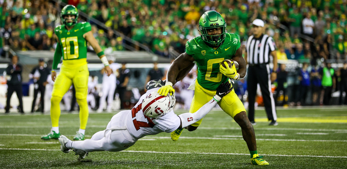Oregon Ducks running back Bucky Irving stiff arms cornerback Kyu Blu Kelly in a game against the Stanford Cardinal.