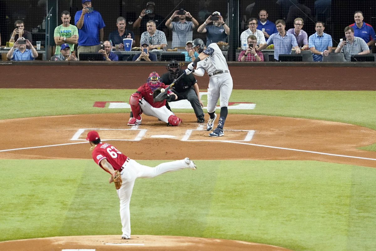 New York Yankees’ Aaron Judge connects for a solo home run, his 62nd of the season, off of Texas Rangers starting pitcher Jesus Tinoco (63) as Texas Rangers catcher Sam Huff and umpire Randy Rosenberg look on in the first inning of the second baseball game of a doubleheader in Arlington, Texas, Tuesday, Oct. 4, 2022. With the home run, Judge set the AL record for home runs in a season, passing Roger Maris.