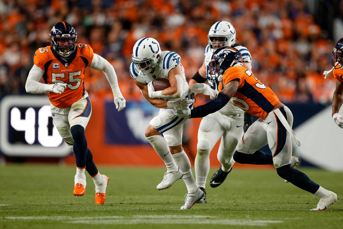 Oct 6, 2022; Denver, Colorado, USA; Indianapolis Colts running back Phillip Lindsay (30) runs through the tackle of Denver Broncos safety Caden Sterns (30) as linebacker Bradley Chubb (55) defends in the second quarter at Empower Field at Mile High. Mandatory Credit: Isaiah J. Downing-USA TODAY Sports