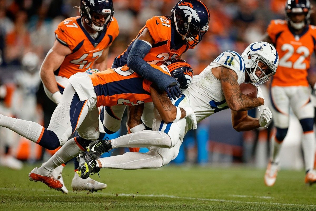 Indianapolis Colts wide receiver Michael Pittman Jr. (11) is tackled by Denver Broncos cornerback Ronald Darby (23) and cornerback K'Waun Williams (21) in the second quarter at Empower Field at Mile High.