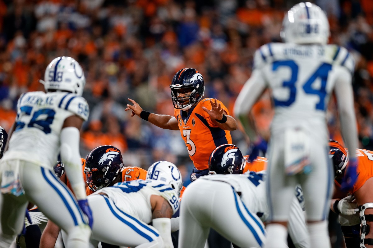 Denver Broncos quarterback Russell Wilson (3) gestures at the line of scrimmage as Indianapolis Colts linebacker Bobby Okereke (58) and cornerback Isaiah Rodgers Sr. (34) look on in the third quarter at Empower Field at Mile High.
