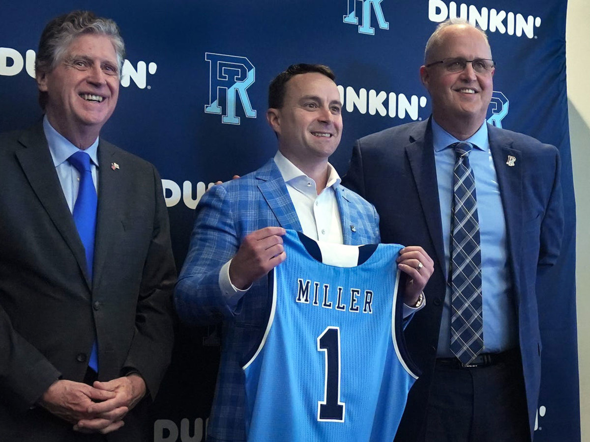 Archie Miller holds a Rhode Island jersey at his introduction
