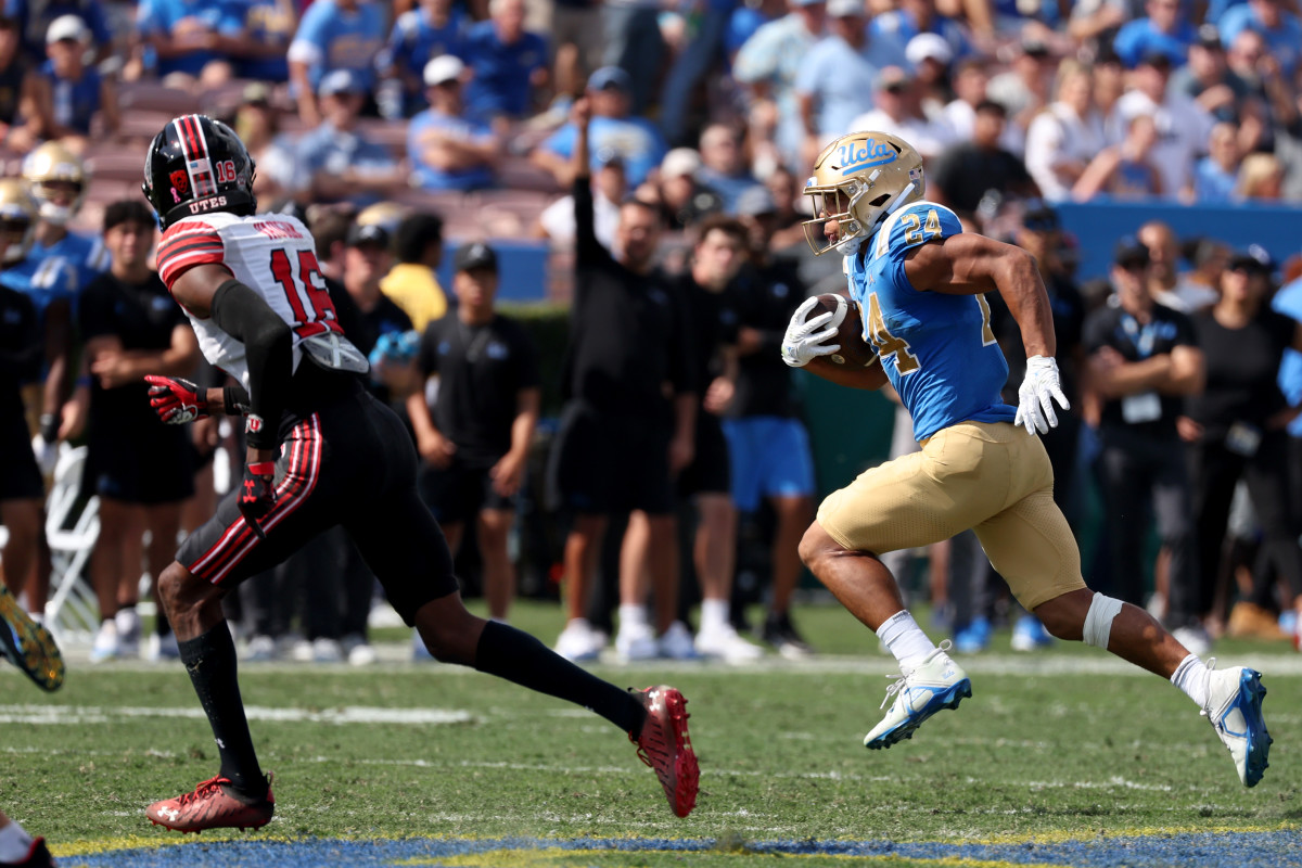 UCLA Bruins running back Zach Charbonnet (24) runs with a ball against Utah Utes cornerback Zemaiah Vaughn (16) during the second quarter at Rose Bowl.