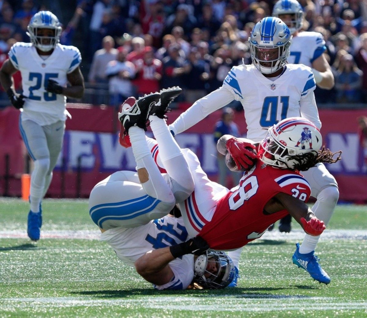 Patriots running back Rhamondre Stevenson runs over the Lions' Alex Anzalone in Week 5.