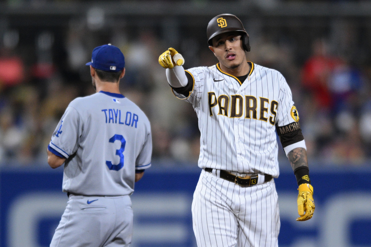 Padres player Manny Machado points while standing next to Chris Taylor