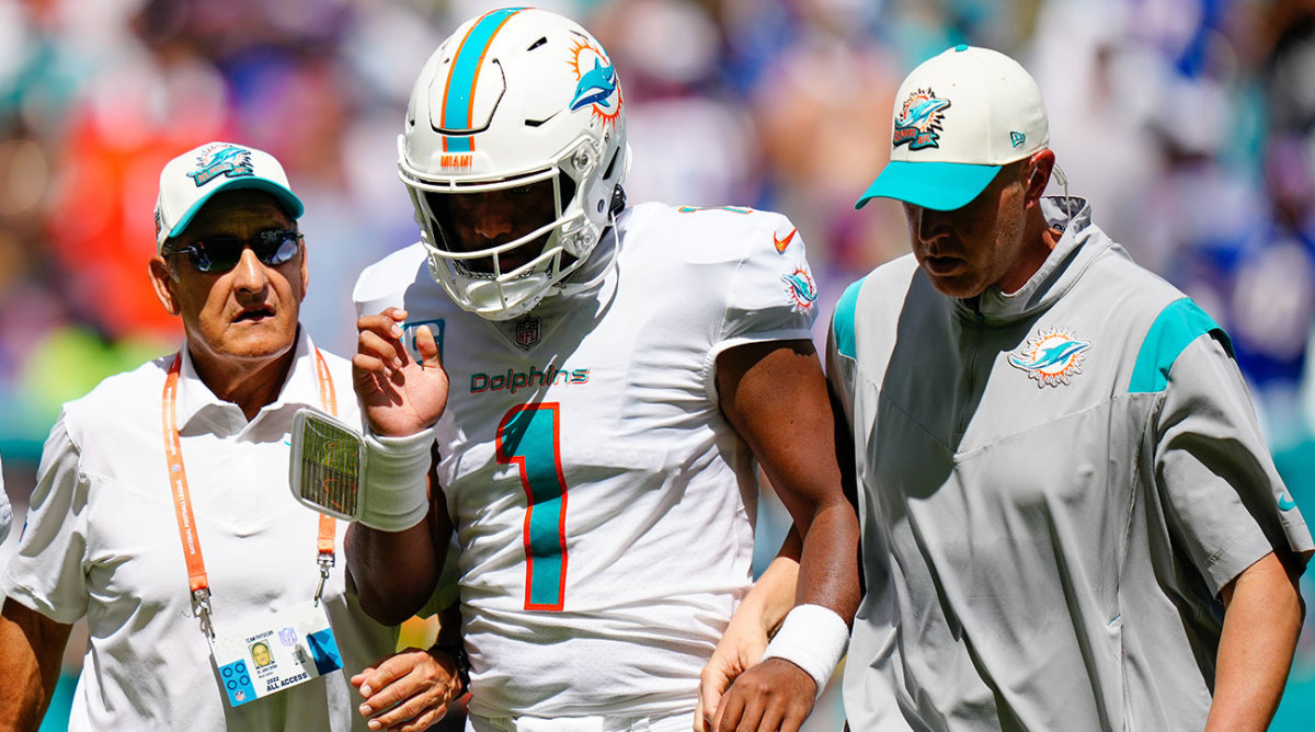 Dolphins QB Tua Tagovailoa walking off the field with team staff after sustaining an injury