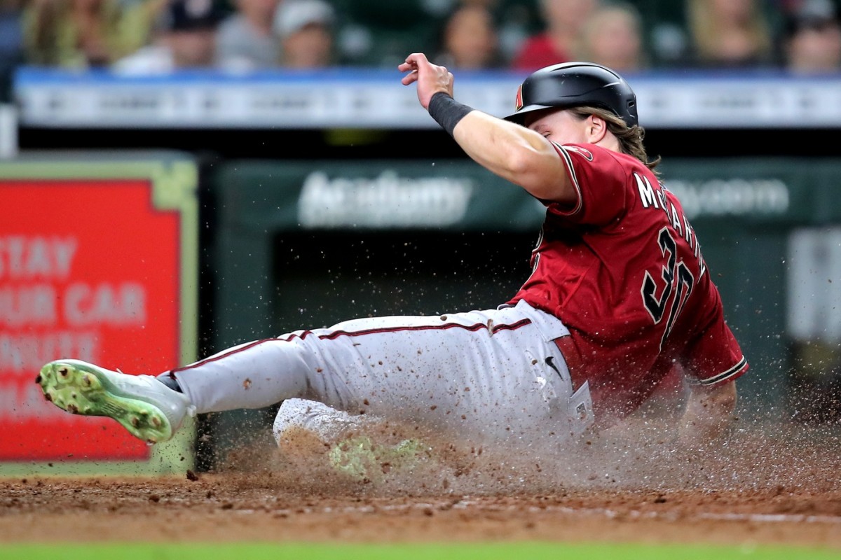 Sep 28, 2022; Houston, Texas, USA; Arizona Diamondbacks right fielder Jake McCarthy (30) slides across home plate to score a run against the Houston Astros during the tenth inning at Minute Maid Park. Mandatory Credit: Erik Williams-USA TODAY Sports