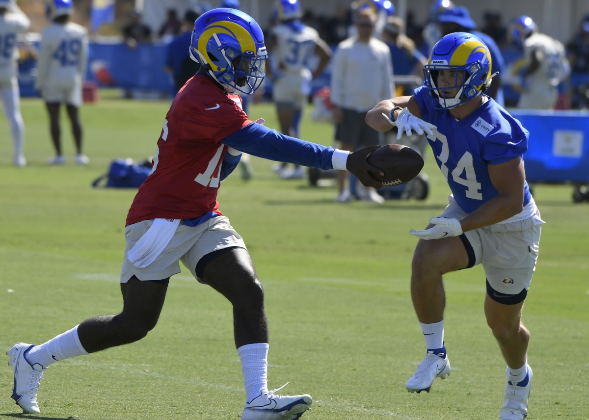 Jul 29, 2021; Los Angeles Rams quarterback Brice Perkins (16) hands the ball off to running back Jake Funk (34) during training camp. Mandatory Credit: John McCoy-USA TODAY