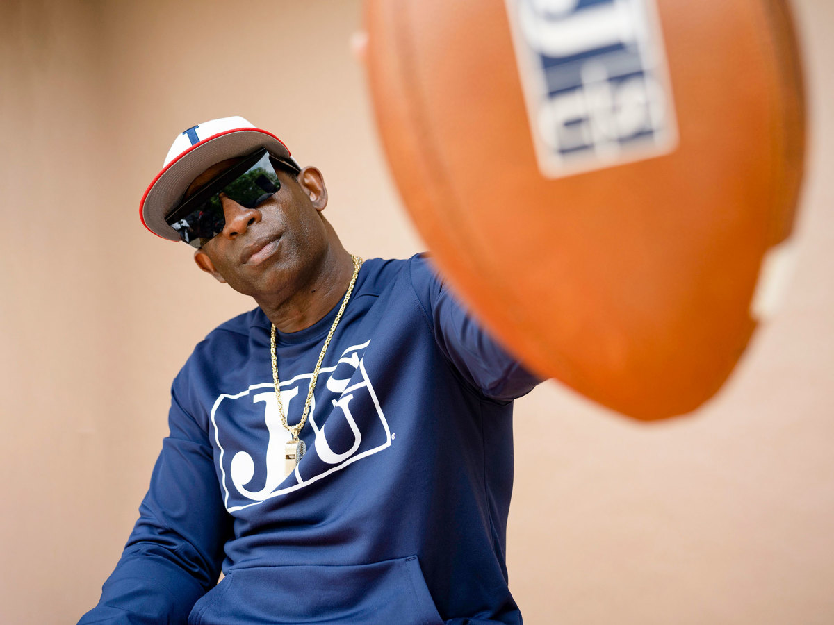 Deion Sanders holds up a football to the camera