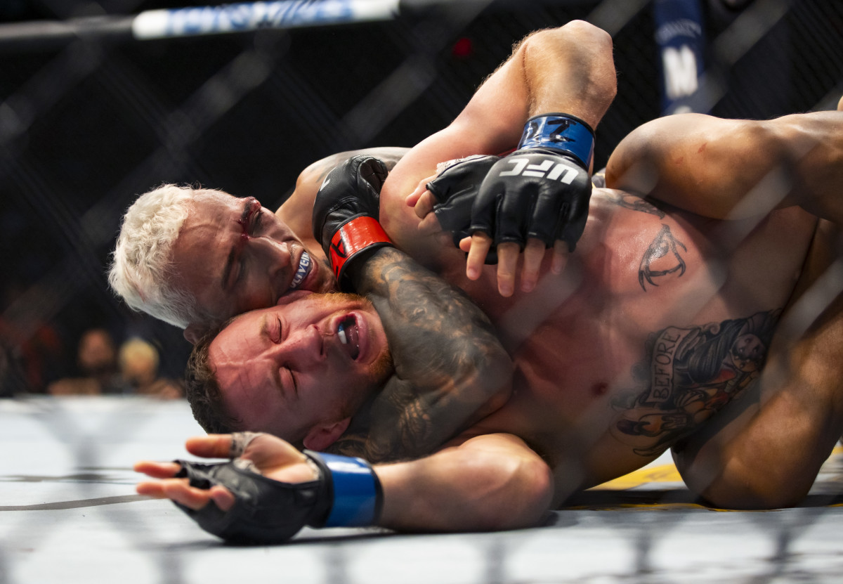 Charles Oliveira (left) chokes Justin Gaethje during UFC 274 at Footprint Center.