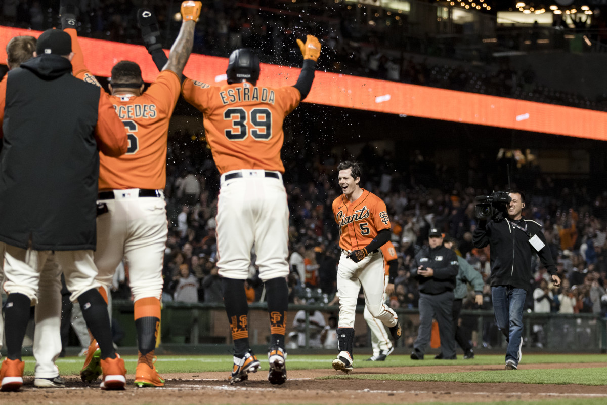 The SF Giants form a circle around home plate after Mike Yastrzemski's walk-off grand slam against the Brewers. (2022)
