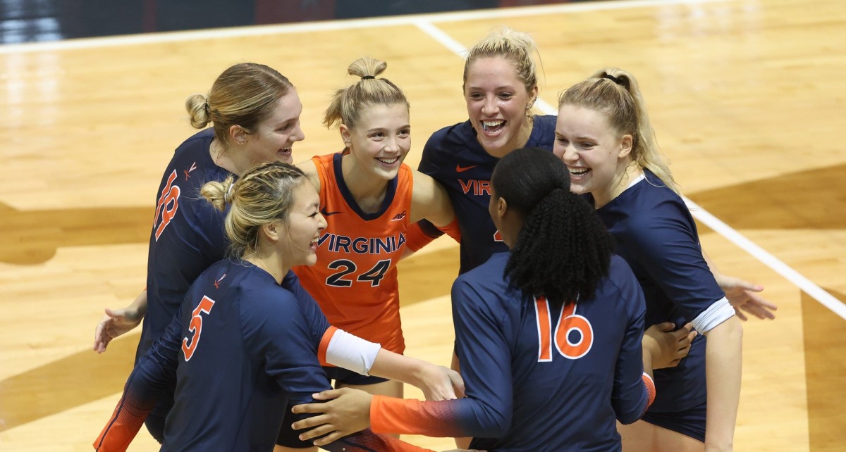 The Virginia Cavaliers volleyball team celebrates after scoring a point against Florida State.