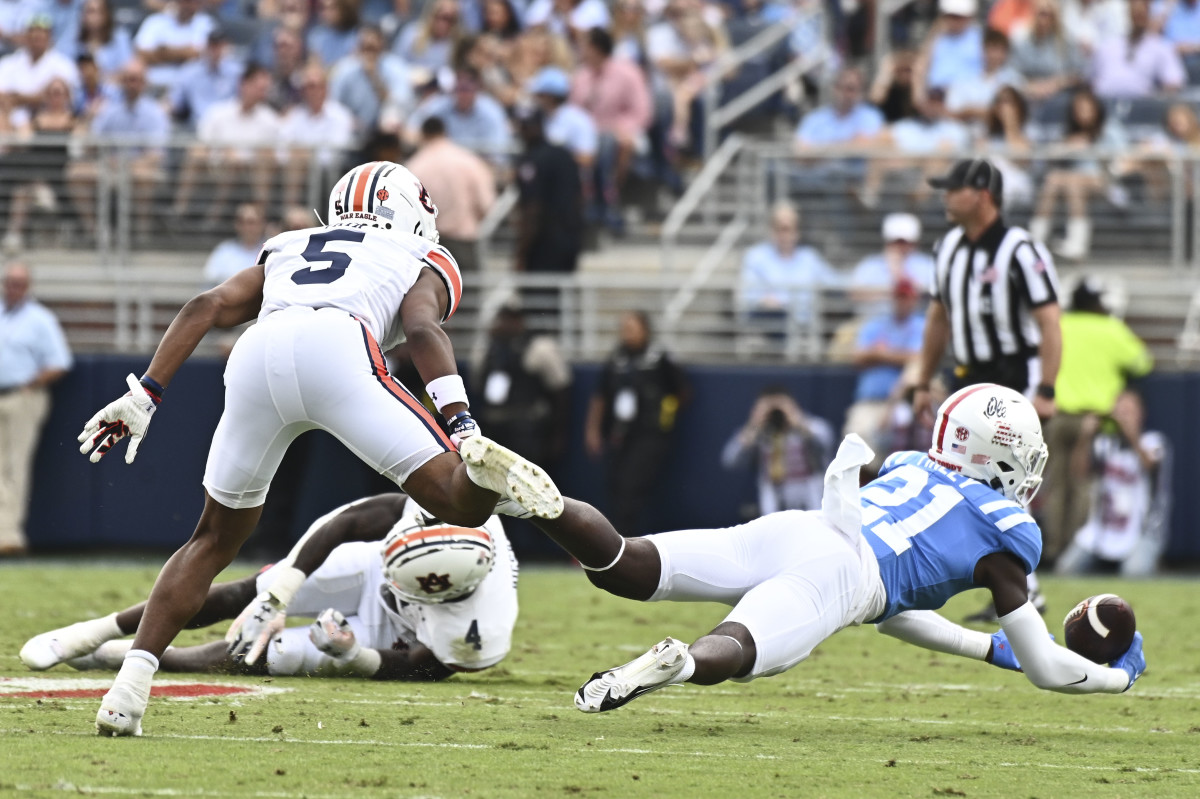 Oct 15, 2022; Oxford, Mississippi, USA; Mississippi Rebels safety AJ Finley (21) intercepts a pass while defended by Auburn Tigers wide receiver Jay Fair (5) during the first quarter at Vaught-Hemingway Stadium. Mandatory Credit: Matt Bush-USA TODAY Sports
