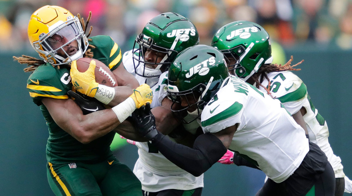 Packers RB Aaron Jones is swarmed by three Jets defenders
